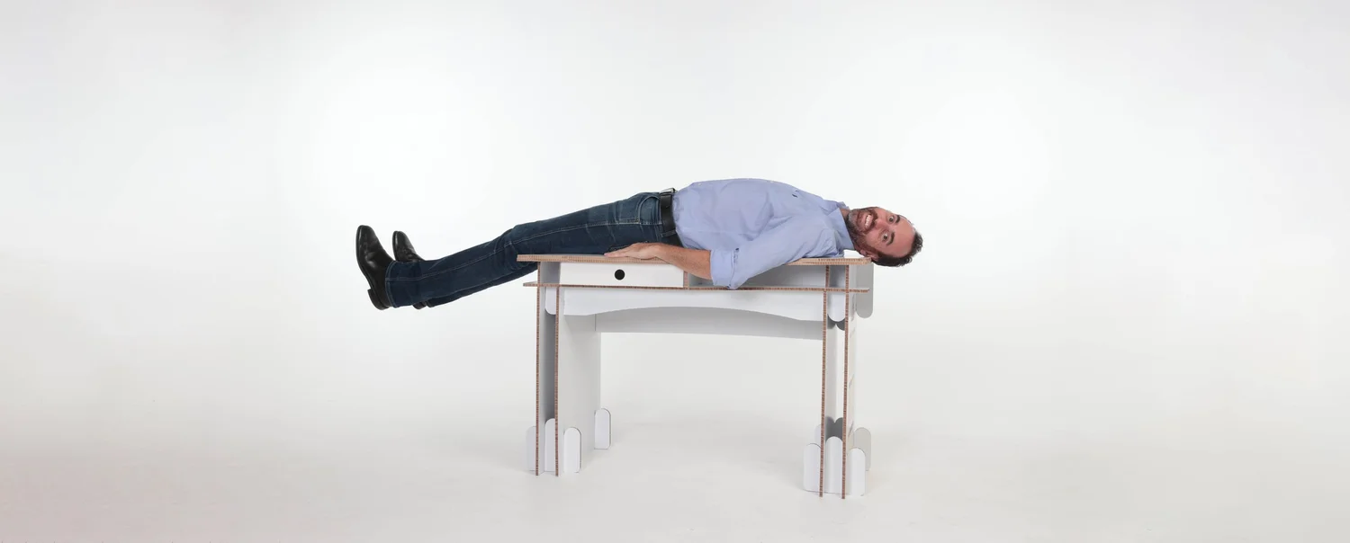 Benn laying on a Build-A-Desk desk